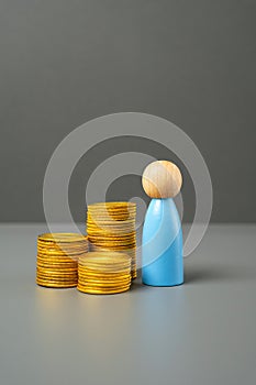 A figurine of a man and a stack of coins. Savings and capital.