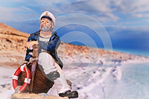 Figurine of an old sailor on a boat on the shore, captain on the shore, captain on the boat