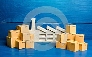 A figurine of a plant and a lot of boxes. The concept of overproduction of goods. Overstocking of manufacturer`s warehouses, low photo