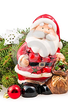 Figurine of Santa Claus near the branch of a Christmas tree