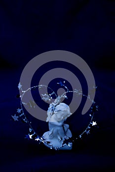 Figurine of a sleeping angel on a blue background.