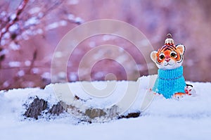 Figurine of tiger, wooden fir trees in snow on beige background. Tiger symbol of the Chinese new year 2022