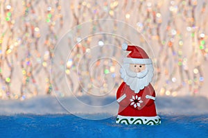 Figurine toy Santa Claus on colorful undulation bokeh background