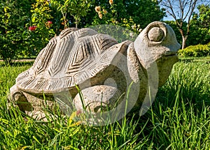 Figurine Turtle made of stone sitting on green grass