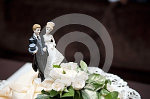 Figurines of the bride and groom at the top of the wedding cake, close-up. copy space