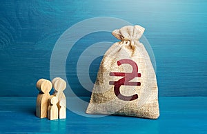 Figurines of a family and a bag of money Ukrainian hryvnia. Financial and humanitarian assistance to refugees and war affected