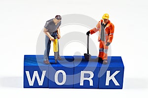 Figurines on top of the word work