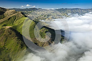 Fiji aerial of green mountains with thick white fog