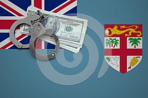 Fiji flag with handcuffs and a bundle of dollars. The concept of breaking the law and thieves crimes