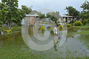 Fijian girl walks over flooded land in Fiji