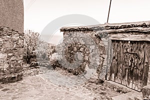 Fikardou village scene with blooming almond trees- sepia toned