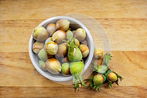 Filberts or hazelnuts and leaves on the wooden surface. Top view.