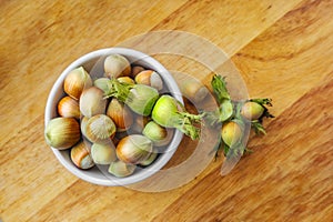 Filberts or hazelnuts and leaves on the wooden surface. Top view.