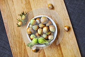 Filberts or hazelnuts and leaves on the wooden surface. Top view.