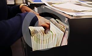 File cabinet, legal documents and person hands with management of tax report at office. Accountant, worker and notes in