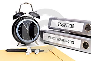 File folders and alarm clock symbolize time pressure. Translation: 