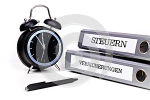 File folders and alarm clock symbolize time pressure. Translation: 