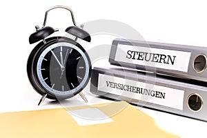 File folders and alarm clock symbolize time pressure. Translation: 