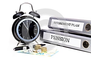 File folders and alarm clock symbolize time pressure while working on retirement plan and pension