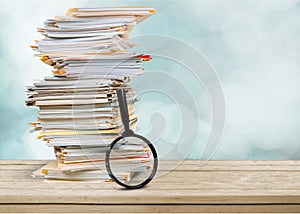 File folders with documents and magnifying glass