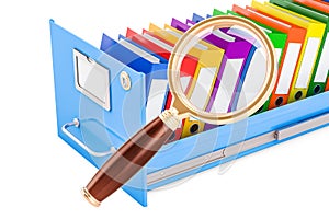 File search concept. Folders inside filing cabinet with magnifyi photo