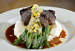 Filet on a bed of asparagus and mashed potatoes with gravy