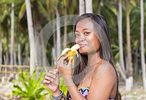 Filipina girl eating banana