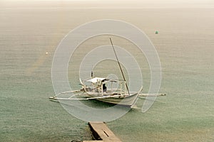 Filipino Banca boats being drenched by a midday rain