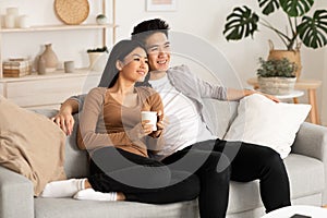 Filipino couple resting at home and watching tv photo