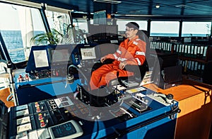 Filipino deck Officer on bridge of vessel or ship. He is looking forward to sea