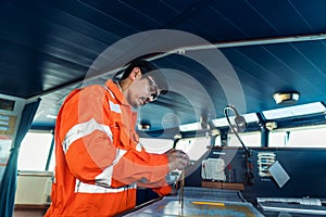 Filipino deck Officer on bridge of vessel or ship. He is plotting position on chart