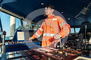 Filipino deck Officer on bridge of vessel or ship. He is speaking on GMDSS VHF radio