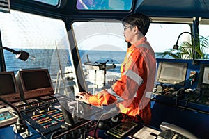 Filipino deck Officer on bridge of vessel or ship. He is speaking on GMDSS VHF radio