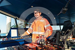 Filipino deck Officer on bridge of vessel or ship. He is speaking on GMDSS VHF radio