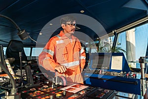 Filipino deck Officer on bridge of vessel or ship. He is speaking on GMDSS VHF radio