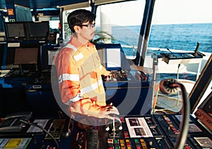 Filipino deck Officer on bridge of vessel or ship. He is speaking on GMDSS VHF radio