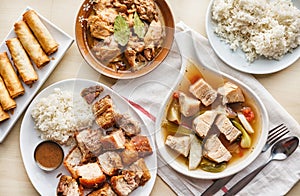 Filipino dinner with sinigang, lechon kawali, and chicken adobo
