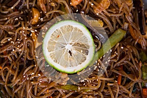 A Filipino noodle cuisine called pansit served with sliced lemon for garnish