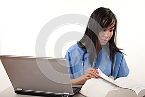 Filipino nurse doctor working on laptop