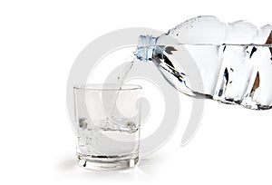 Bottiglia d`acqua versata in un Bicchiere photo