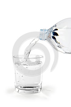 Bottiglia di acqua versata in un Bicchiere photo