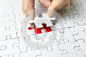 Fill the missing parts of hand white jigsaw concept puzzle for succeed