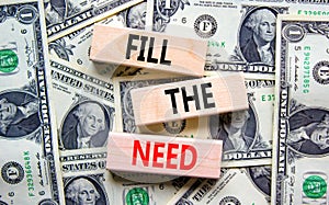 Fill the need symbol. Concept words Fill the need on wooden blocks on a beautiful background from dollar bills. Business, finacial