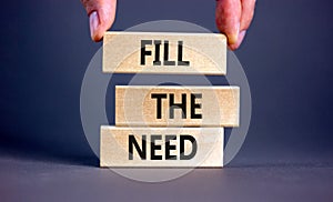 Fill the need symbol. Concept words Fill the need on wooden blocks on a beautiful grey table grey background. Businessman hand.