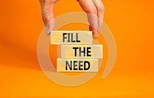 Fill the need symbol. Concept words Fill the need on wooden blocks on a beautiful orange table orange background. Businessman hand