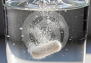 Filled with clear liquid, and the background is blurred, emphasizing the