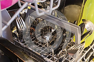 Filled cutlery basket in a dishwasher