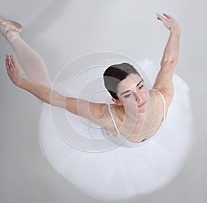 Filled with elegance and grace. Supple young ballerina dancing against a white background.