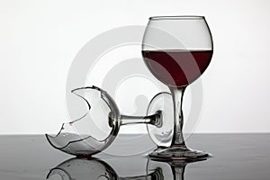 Filled with a glass of wine and broken wine glass with red wine