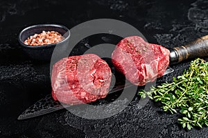 Fillet Mignon Beef steak, raw dry aged marble meat. Black background. Top view